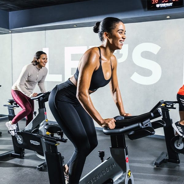A view of two people cycling during a cycling class at a Virgin Active Red Club gym floor, which is an option for Virgin Active gym memberships in South Africa.
